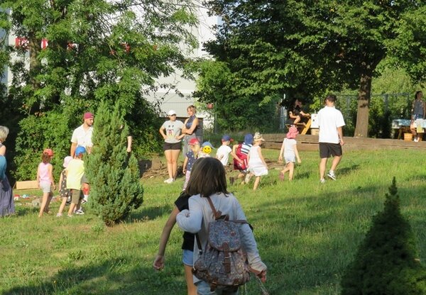 Kinder werden von den Auszubildenden zu Erzieher*innen zum Sinnespfad im großen Garten begleitet.