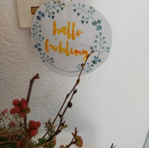 Frühlingserwachen Kärtchen auf dem Hallo Frühling steht hängt an der Wand.
