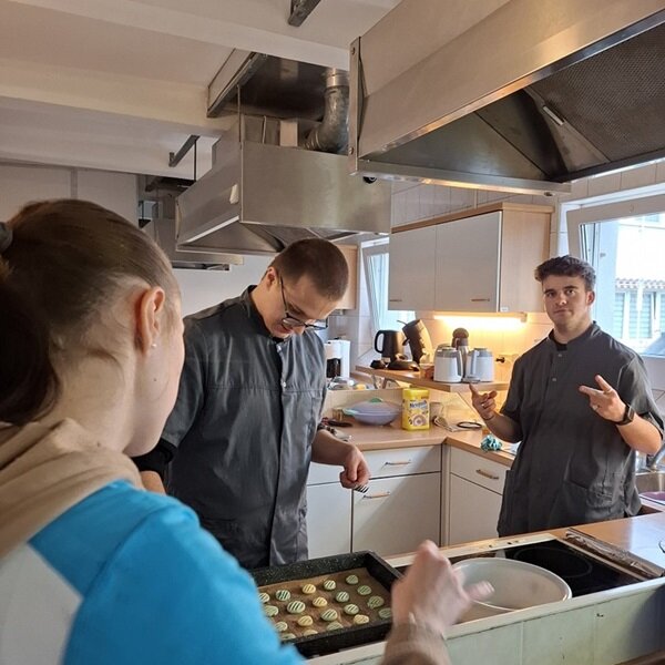 Es weihnachtet sehr... Drei Auszubildende stehen in einer Großküche und backen Plätzchen.