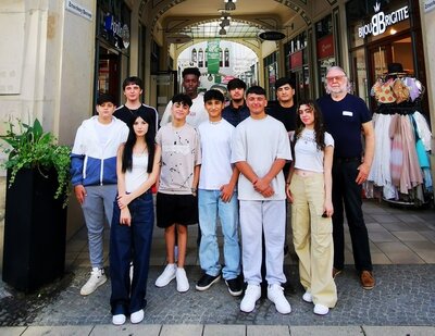 Gruppenfoto Schülerinnen und Schüler posieren draußen mit einer Lehrkraft für ein Gruppenfoto.