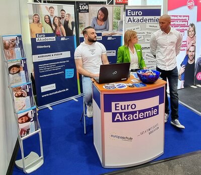 Drei Mitarbeitende der Euro Akademie und Euro-Schulen Oldenburg stehen an ihrem Messestand auf der 19. Jobmesse in Oldenburg.