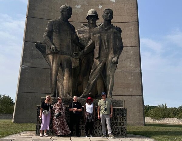 Ausflug zur Gedenkstätte Sachsenhausen Teilnehmende stehen vor der überlebensgroßen Skulpturengruppe, die den Titel "Befreiung" trägt und vom Bildhauer René Graetz stammt.