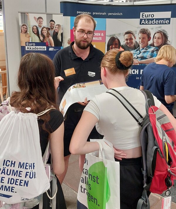 Messe Forum Berufsstart Erfurt Zwei interessierte Schülerinnen lassen sich von Euro Akademie Mitarbeiter informieren.