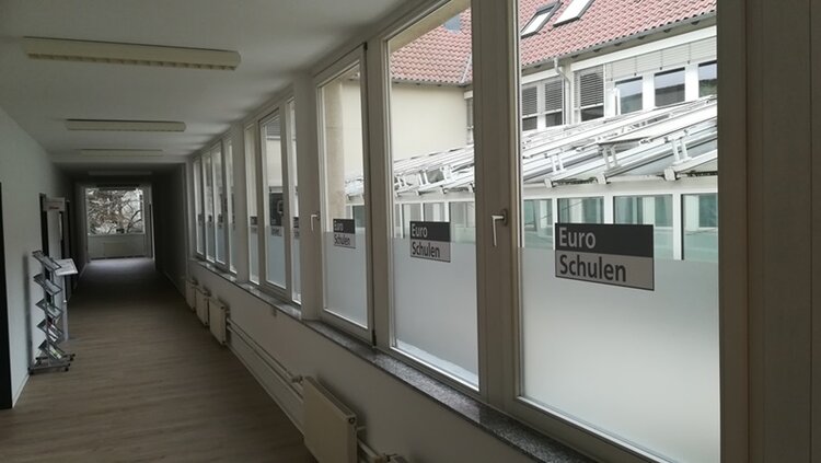 Neues Leitungsteam in Potsdam Langer Flur mit Fensterfront der Euro-Schulen Leipzig.