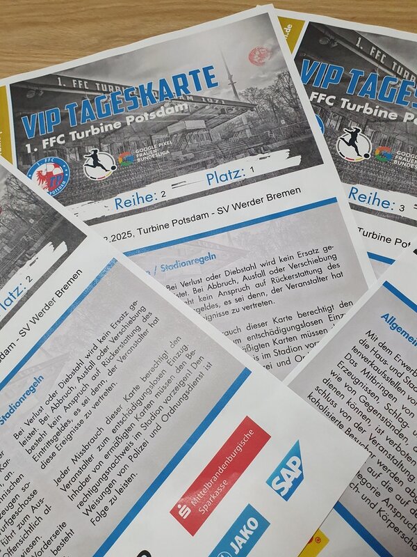 Stadionerlebnis der Extraklasse bei Turbine Potsdam Auf einem Tisch liegen übereinander gefächert vier VIP Tageskarten des 1. FFC Turbine Potsdam, für das Spiel gegen SV Werder Bremen. Auf der Karte ist ein Schwarz-Weiß-Bild des Stadions abgedruckt, darunter ist der Spieltag angegeben und die Stadionregeln sind vermerkt.