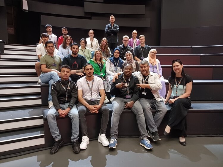 Berufssprachkurs besucht Fernsehsender Für ein gemeinsames Gruppenbild posieren die Teilnehmenden gut gelaunt auf den Zuschauerplätzen des Fernsehstudios.