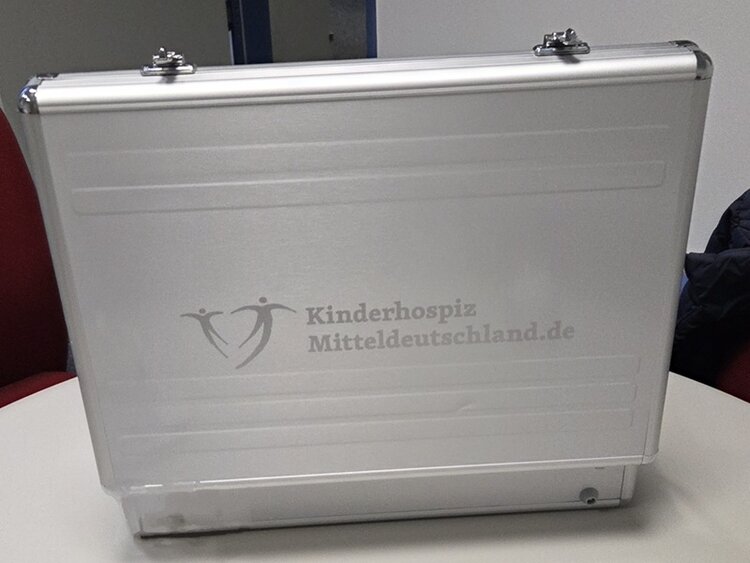 Spende an das Kinder- und Jugendhospiz Ein geöffneter Aluminiumkoffer, auf dem der Schriftzug Kinderhospiz Mitteldeutschland.de steht