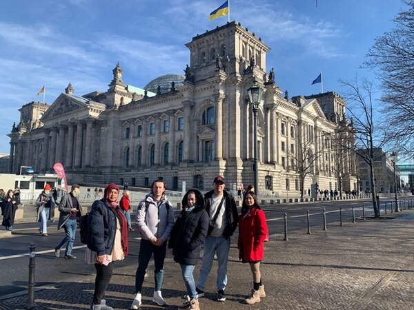 Teilnehmende posieren vor dem Gebäude des Deutschen Bundestages für ein Gruppenfoto.