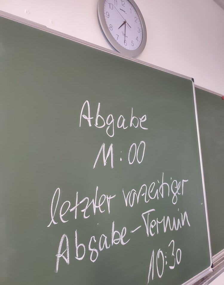 Prüfungsphase beginnt Auf einer Tafel im Klassenraum stehen die Absagetermine zur heutigen schriftlichen Prüfung im Fach Englisch.
