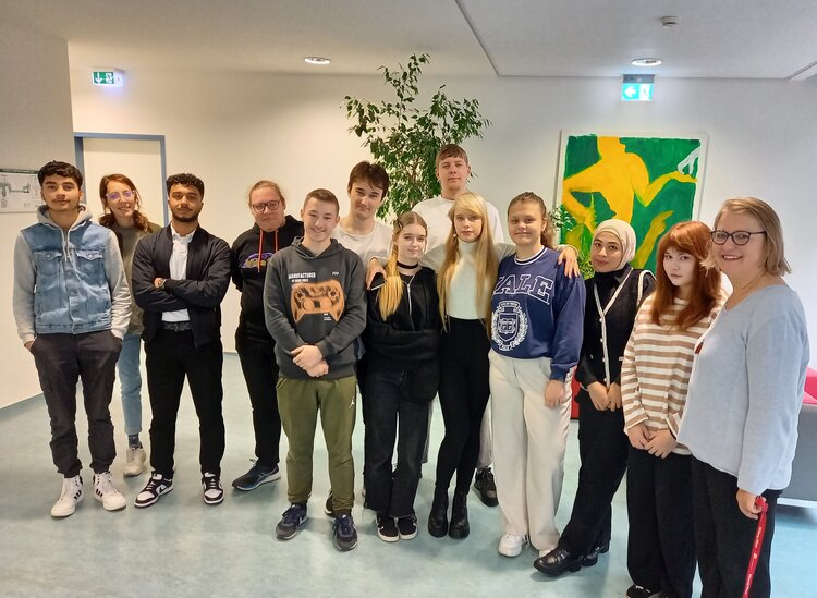 KarriereStart II an den Euro-Schulen Leipzig Junge Menschen beider Geschlechter stehen in einem Flur und lächeln in die Kamera.