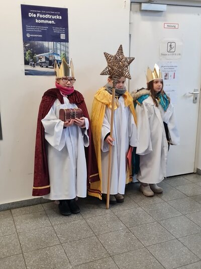 Foto Die kleinen Sternsinger posieren zauberhaft verkleidet als Caspar, Melchior und Baltasar für ein Foto.