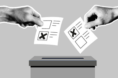 Wahlurne  Auf der Grafik, die komplett in grau gehalten ist, ist eine Wahlurne gezeichnet. Zwei fotografierte Hände halten symbolisch Stimmzettel in der Hand, auf denen jeweils ein Kreuz in einem Kästchen ist. Die Hände bewegen die Zettel in Richtung der Öffnung der Wahlurne.