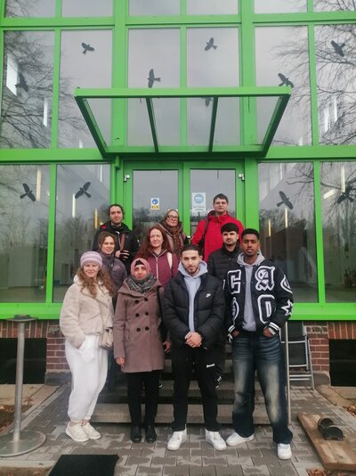 Die Schülergruppe steht vor dem gläsernen Eingang des Wasserwerks.