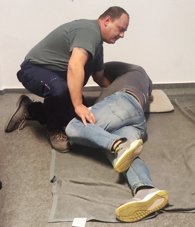 Helfen können alle lernen Zwei Mitarbeitende beim Erste Hilfe Kurs üben die stabile Seitenlage.