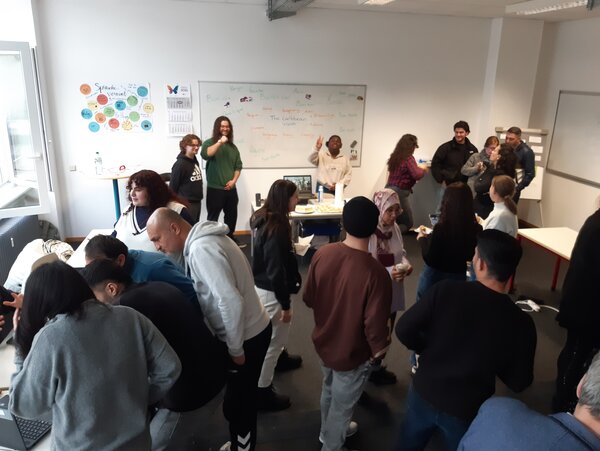 Intercultural Day an der Euro Akademie Mainz – Teilnahme Integrationskurse Schüler*innen und Interessent*innen stehen an Ständen des Intercultural Day an der Euro Akademie Mainz