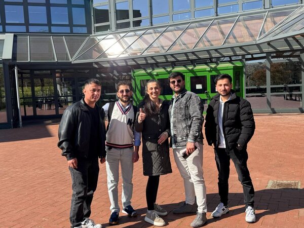 HSA-Kurs besucht Prüfungsschulen Fünf Teilnehmende des HSA-Kurses der Euro-Schulen Düren stehen gemeinsam vor dem Eingangsbereich einer Schule und lächeln in die Kamera.