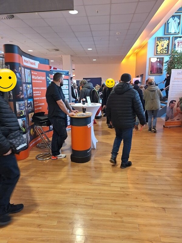 Erfolgreicher Messebesuch Blick in die Messehalle, mit Informationsständen und Besucher*innen.