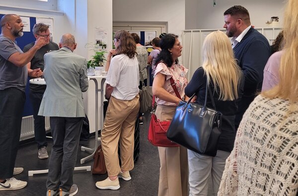 10 Jahre Reinickendorfer Ausbildungsdialog Die Teilnehmenden des Reinickendorfer Ausbildungsdialogs tauschen sich rege aus, an Stehtischen.