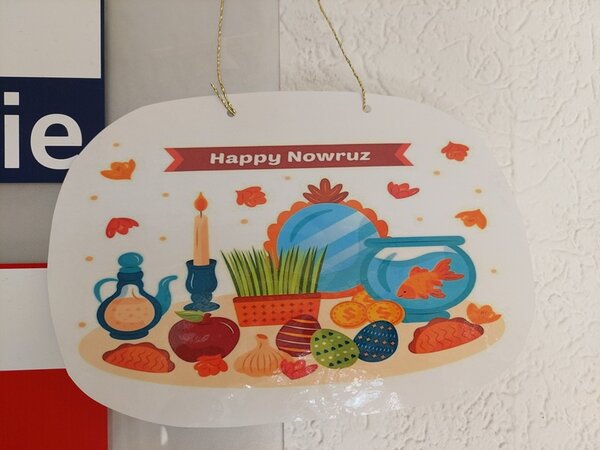 Frühlingserwachen Selbst gestalteter, bunter Anhänger mit mit Schriftzug Happy Nowruz.