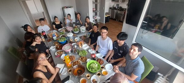 Abschluss des Deutschkurses Die Teilnehmenden sitzen an der gedeckte Tafel mit vielen, selbst zubereiteten vietnamesischen Gerichten.