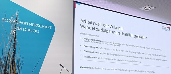 Sozialpartnerschaft im Dialog – Fachtagung am 07.05.2025 Im Hintergrund ist eine Leinwand mit Informationen zur Veranstaltung.