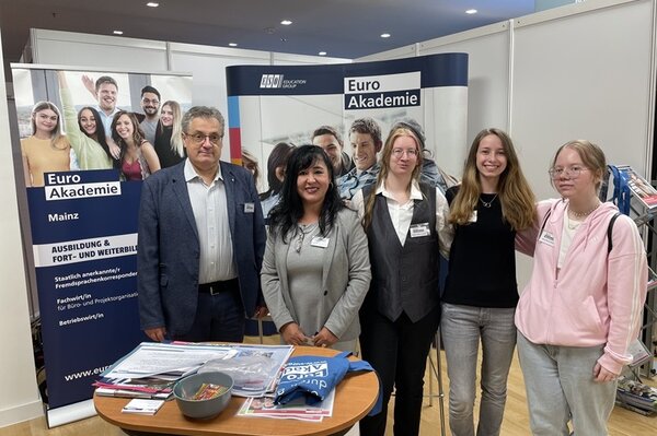 Gruppenfoto am Euro Akademie Messestand mit fünf Teammitgliedern