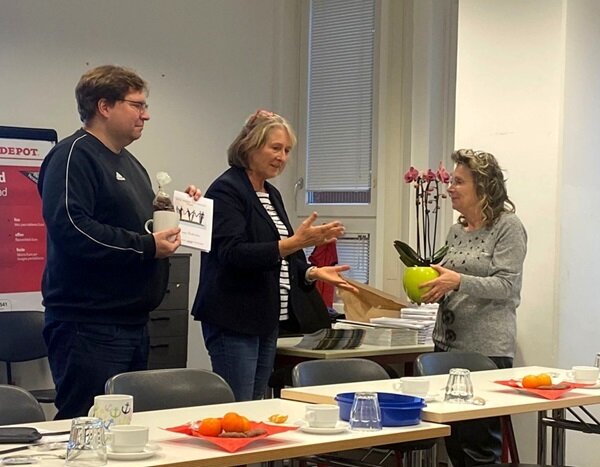Ein Abschied mit Dankbarkeit Zwei leitende Mitarbeitende verbschieden die Kollegin in den Ruhestand und überreichen eine Pflanze und Präsente.