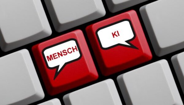 Mit KI zu barrierefreier Bildung – Teil 3 Zwei rote Tasten auf einer Computertastatur, beschriftet mit "MENSCH" und "KI", die als Sprechblasen dargestellt sind, um die Kommunikation zwischen Menschen und künstlicher Intelligenz zu symbolisieren.